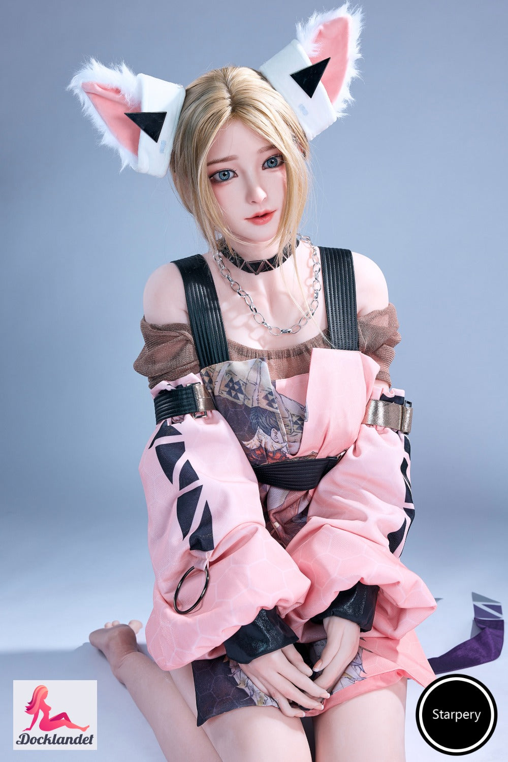 Winni 152 cm Jarliet sexdocka sitter avslappnat i solstol med glittrande guldtopp, brunt hår och realistiskt ansikte i varm kvällsbelysning.